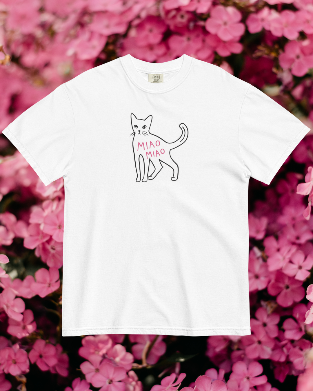 White t-shirt with a cat illustration and 'Miao Miao' text on a pink floral background