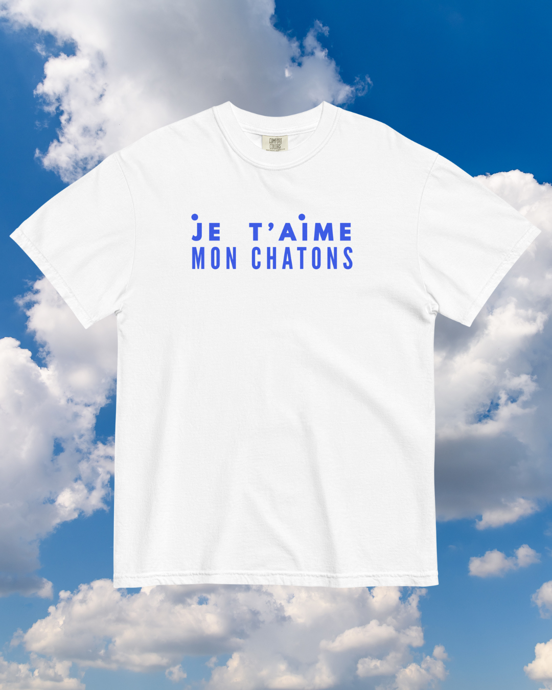 White t-shirt with blue text against a blue sky with clouds