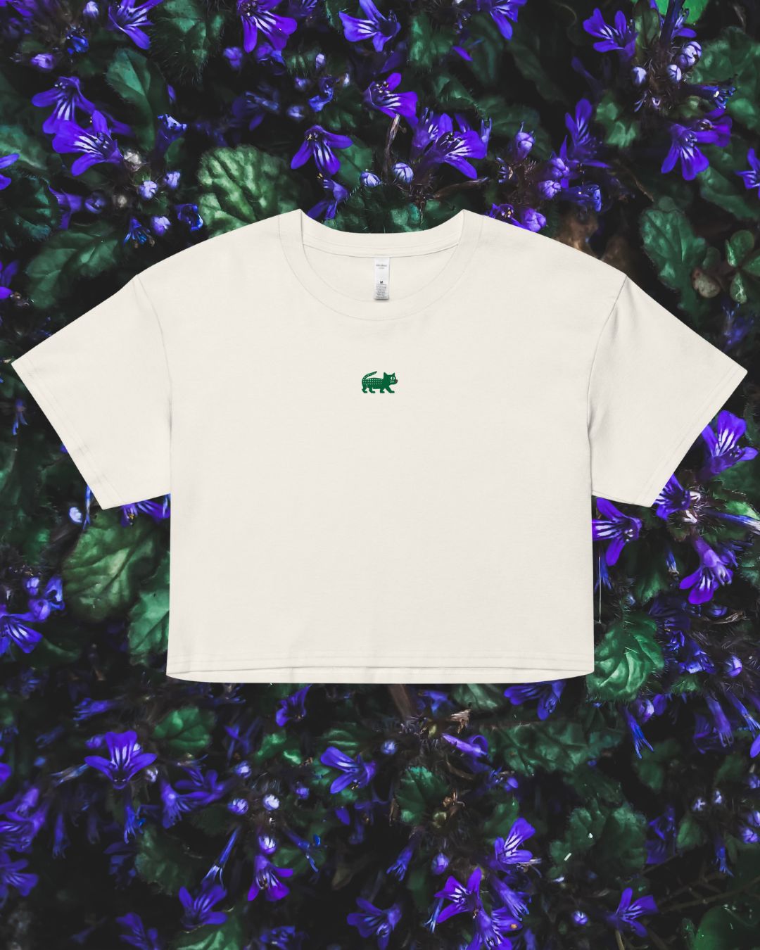 White t-shirt with a green logo on a floral background