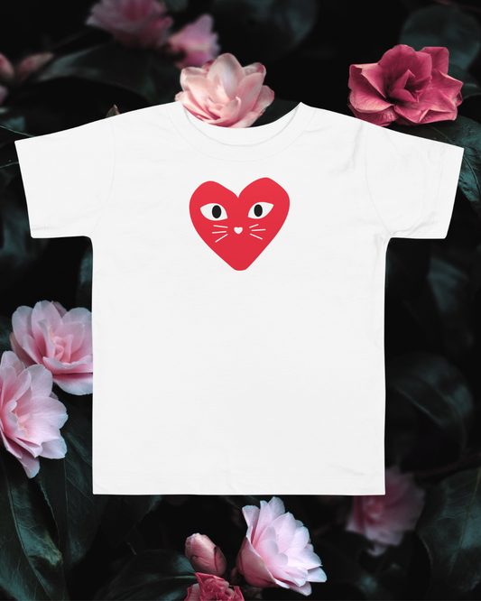 White t-shirt with a red heart design featuring eyes and a mouth, surrounded by pink flowers.