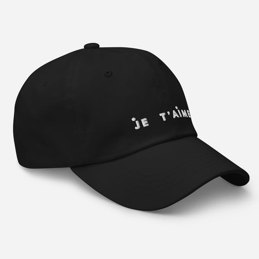 Black cap with 'Je t'aime' text on a light gray background