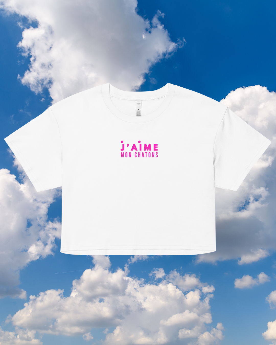 White t-shirt with pink text against a blue sky with clouds