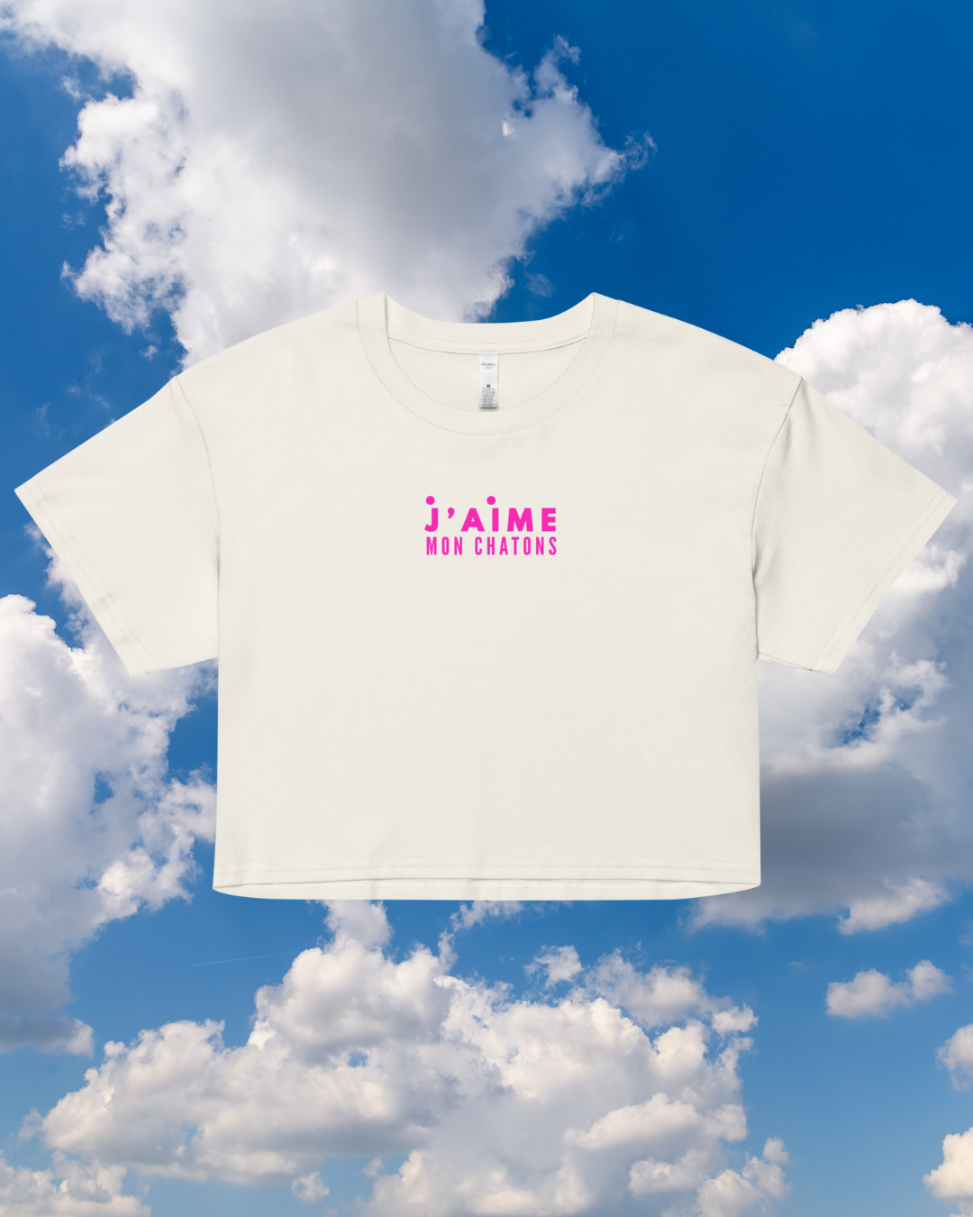 White t-shirt with pink text against a blue sky with clouds