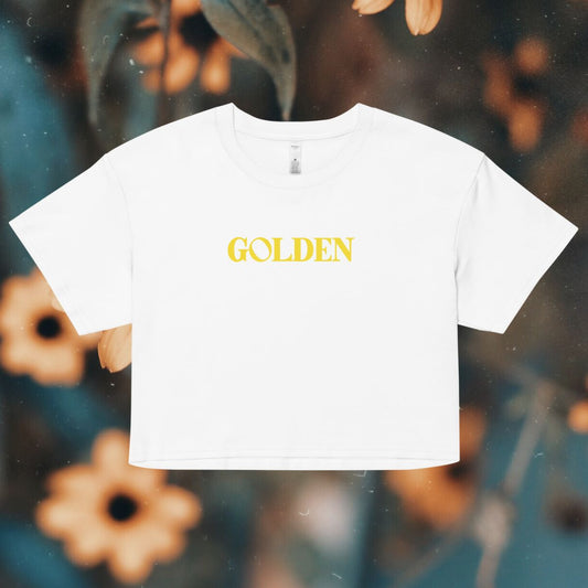 White t-shirt with 'GOLDEN' text on a blurred floral background
