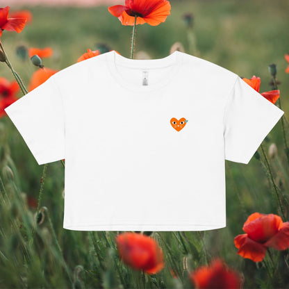 White t-shirt with a small orange heart design in a field of red poppies