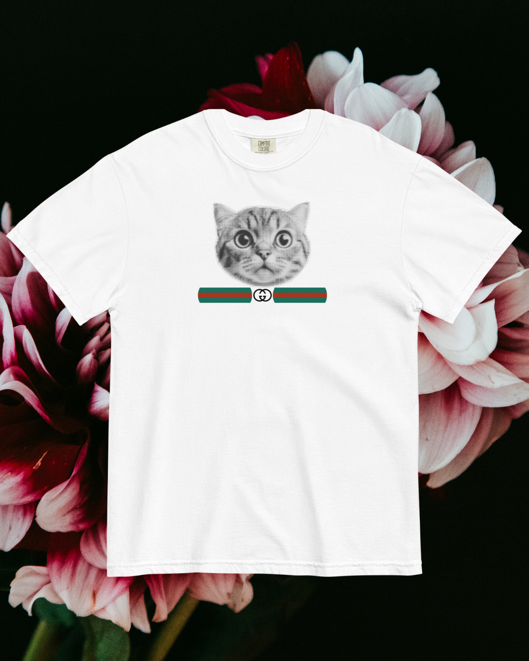White t-shirt with a cat graphic and GG inspired logo on a floral background