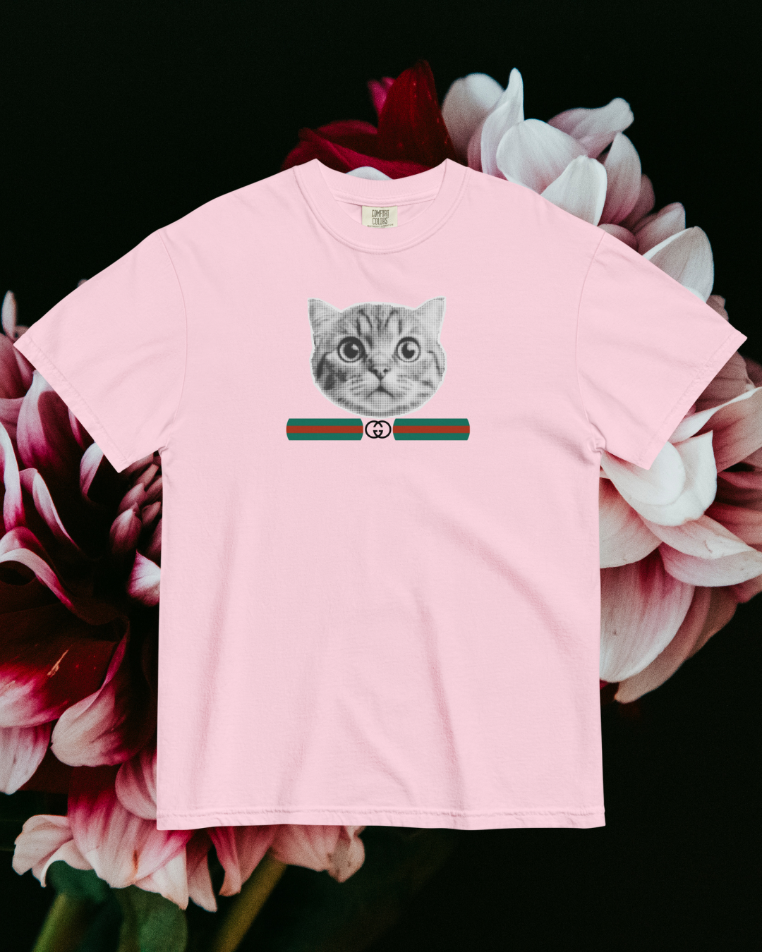 Pink t-shirt with a cat graphic on a floral background