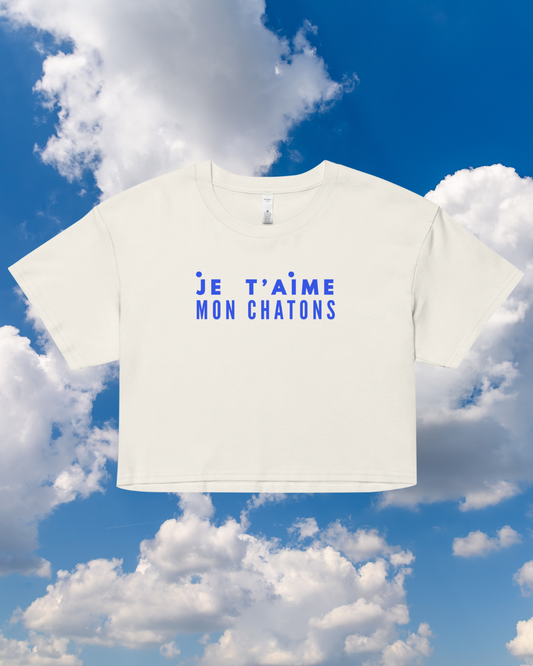 White t-shirt with blue text 'JE T'AIME MON CHATONS' against a blue sky with clouds
