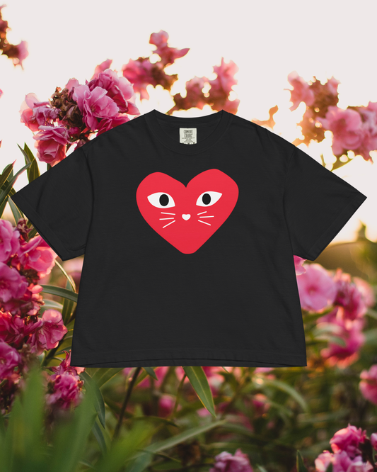 Black t-shirt with a red heart design featuring eyes, nose, and mouth on a floral background