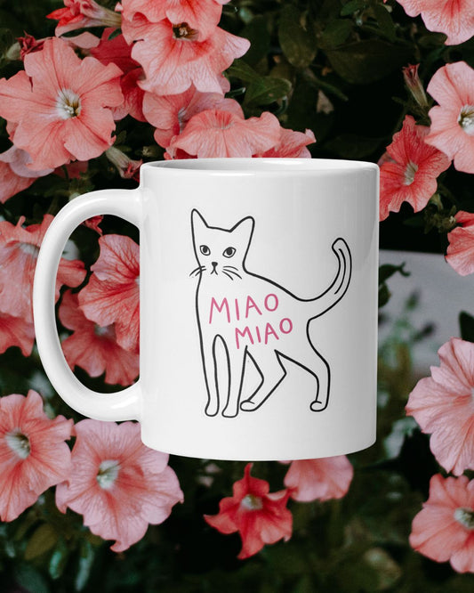 White mug with a cat illustration and 'MIAO MIAO' text on a floral background