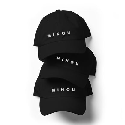 Three black baseball caps with 'MINOU' printed on them against a white background