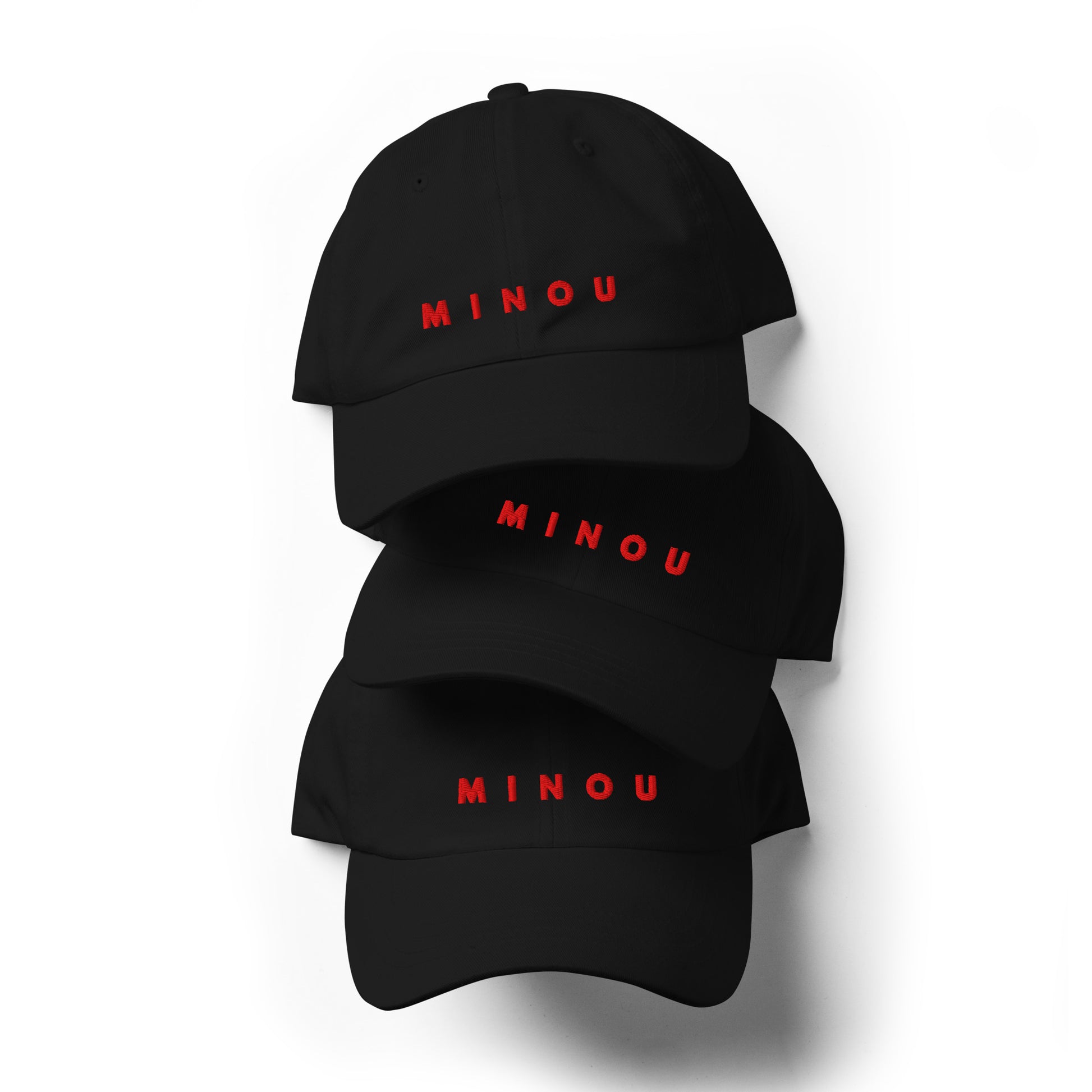 Three black baseball caps with 'MINOU' printed in red on a white background