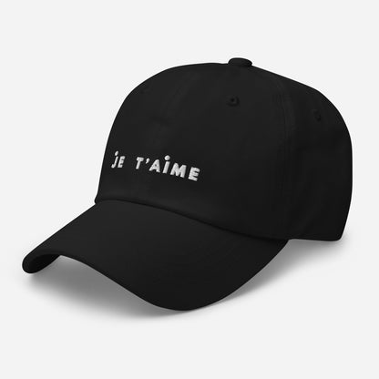 Black cap with 'Je T'aime' text on a light gray background