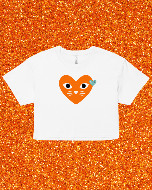 White t-shirt with a heart-shaped cat design on an orange glittery background
